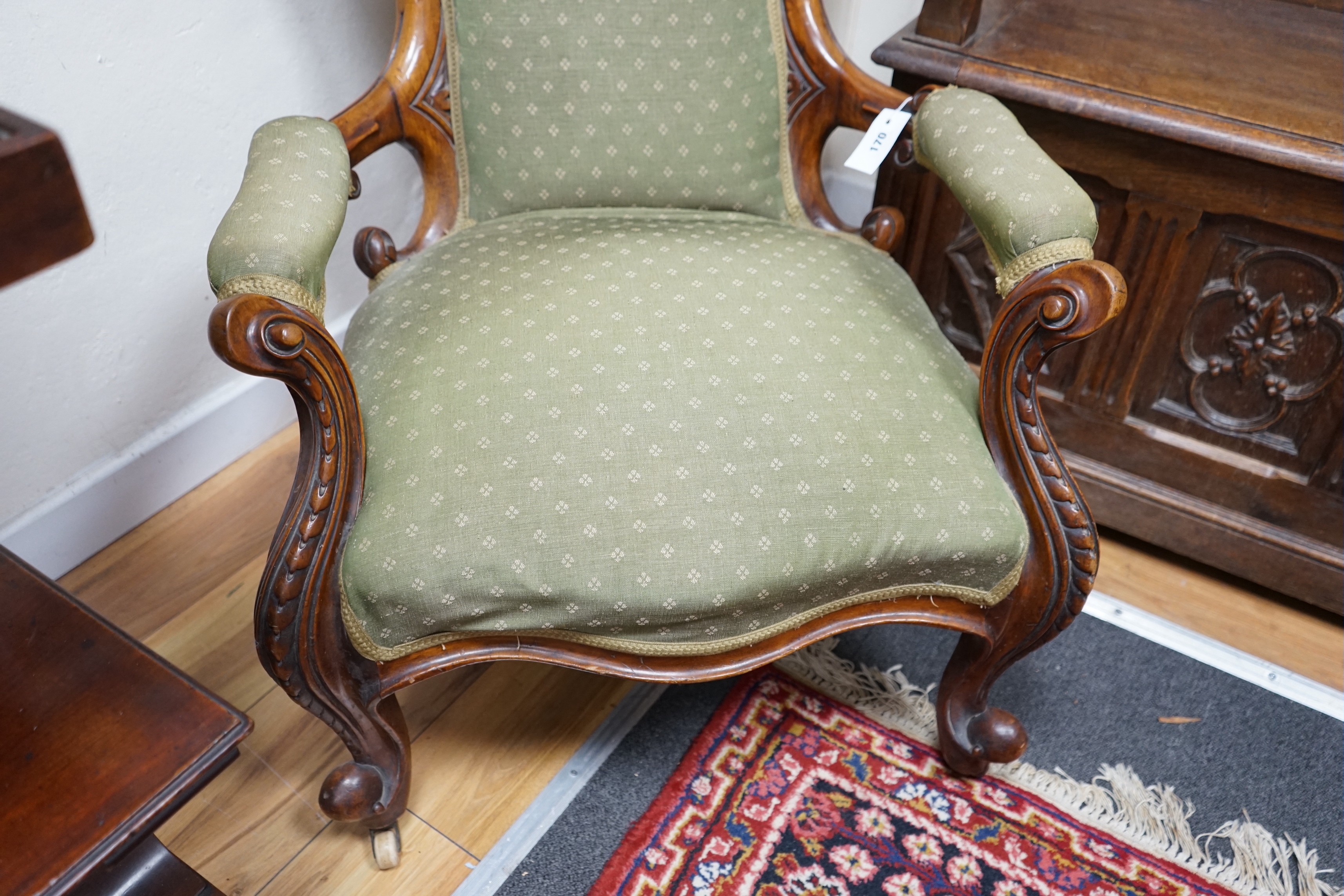 A Victorian walnut spoon back open armchair